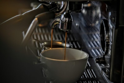 咖啡滴到一个陶瓷杯子从钢机
